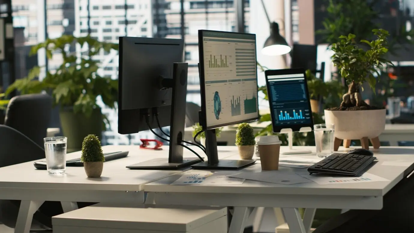 Geschäftsdiagramme und Leistungskennzahlen auf Bildschirmen im Büro